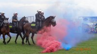 policjanci na koniach pokonują dymną przeszkodę