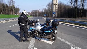 policjant na drodze przy policyjnym motocyklu