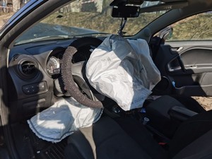 Zdjęcie przedstawia wnętrze uszkodzonego pojazdu - wystrzelone poduszki powietrzne