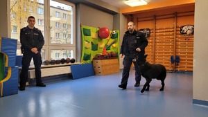 Zdjęcie przedstawia policjantów i psa podczas prelekcji